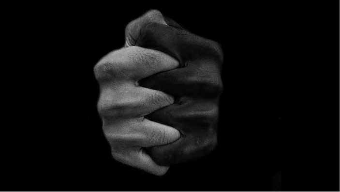 Two hands with interlocked fingers, in black and white